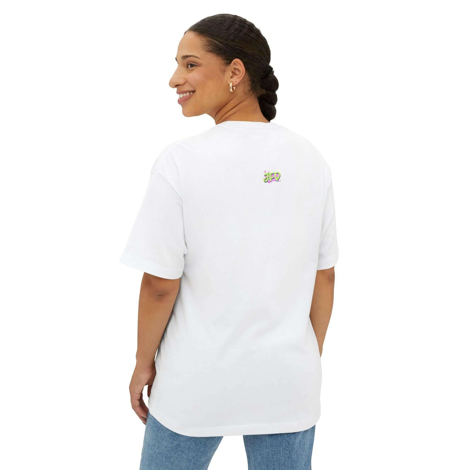 Model wearing a white unisex oversized tee featuring colorful back graphic, showcasing a relaxed and stylish look.