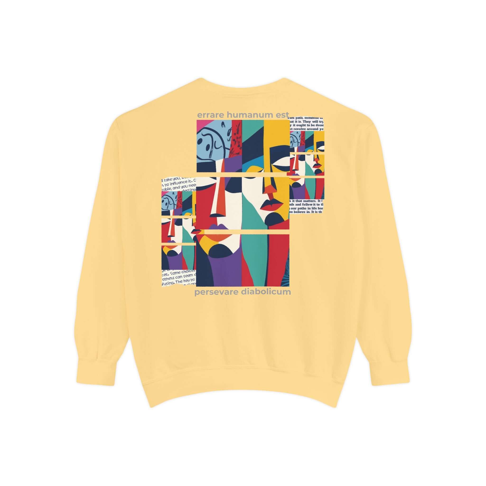 Colorful unisex garment-dyed sweatshirt featuring artistic face designs and motivational quote on a yellow background.