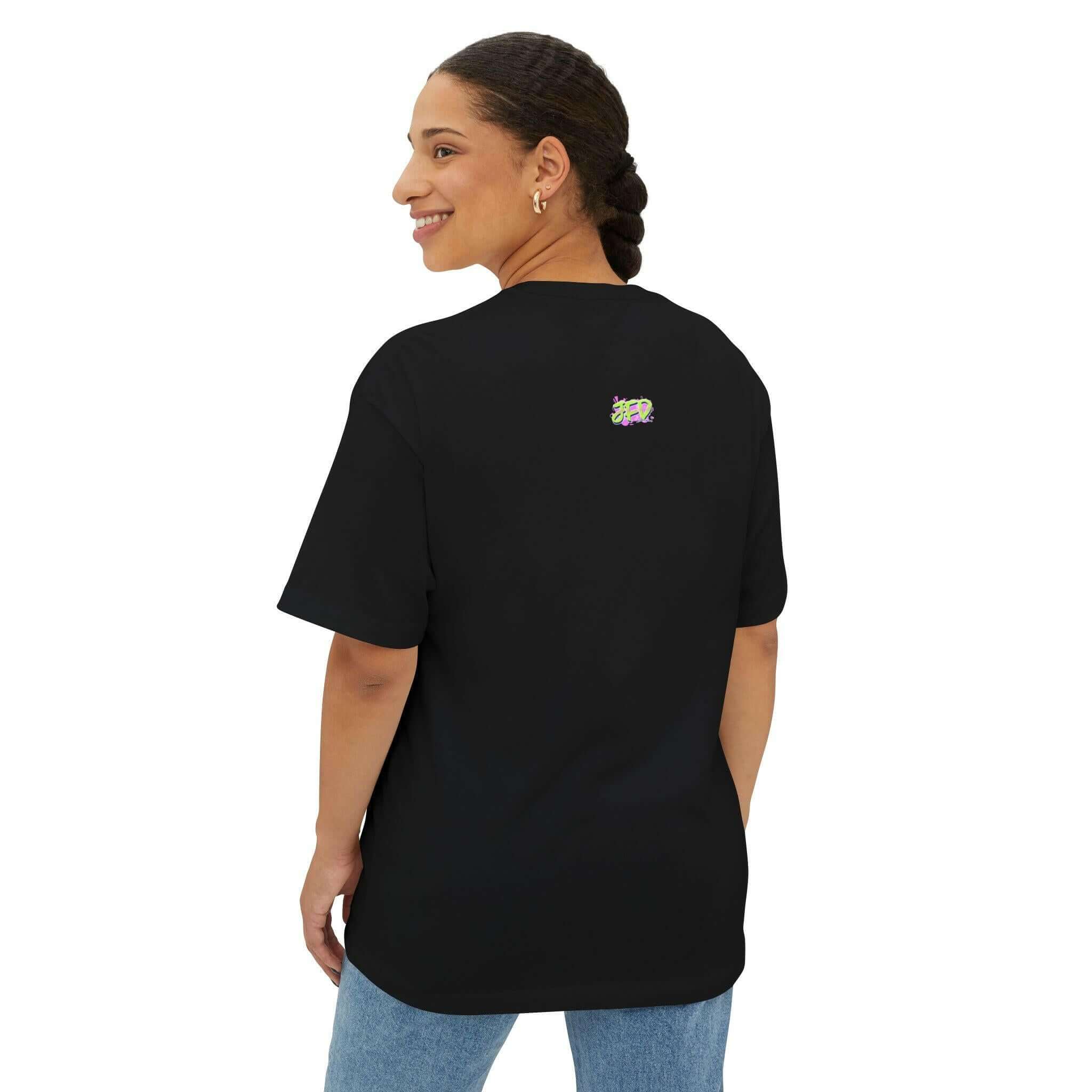 Woman wearing a black unisex oversized tee with colorful artistic design on the back, showcasing a relaxed style.